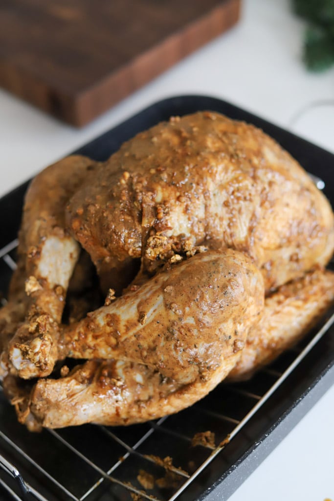 marinated turkey on a roasting rack in a pan