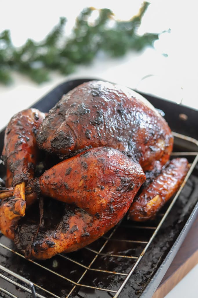 jerk turkey on a roasting rack in a pan