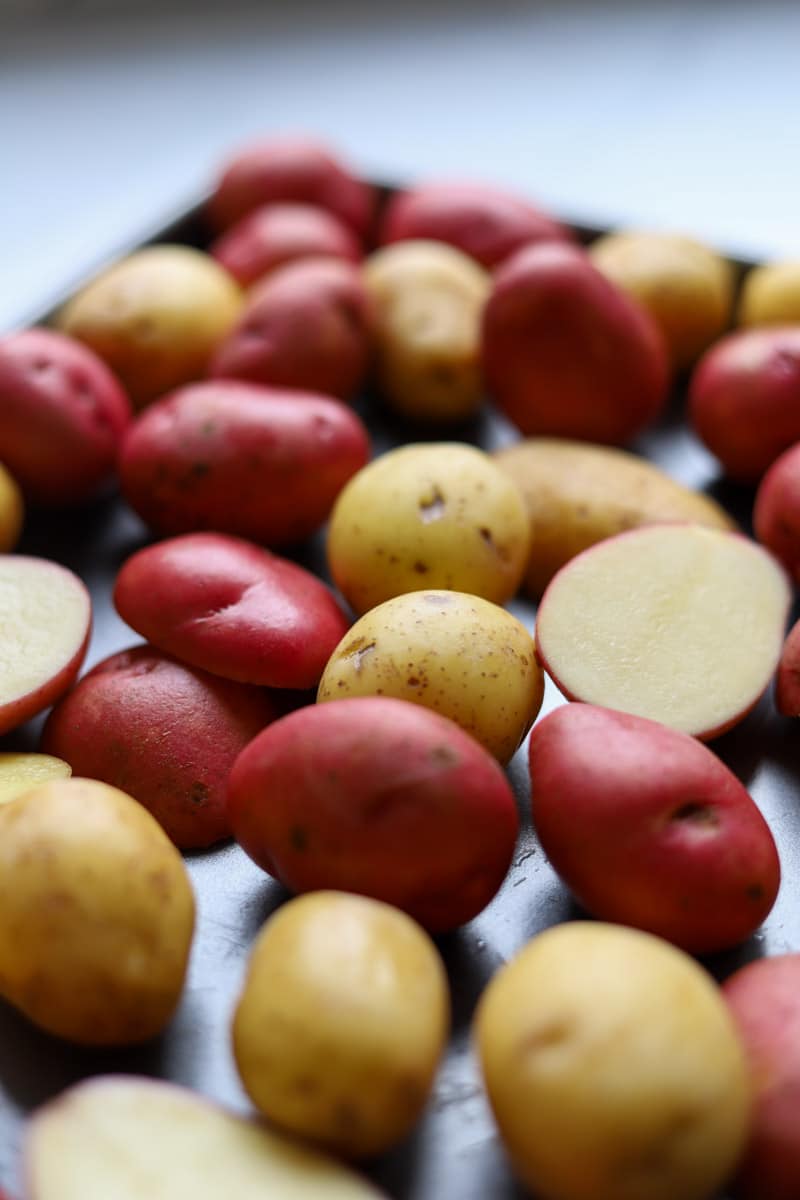 sliced raw potatoes on a baking sheet