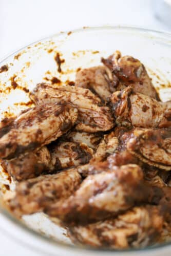 Chicken wings coated in homemade Jamaican jerk marinade in a bowl