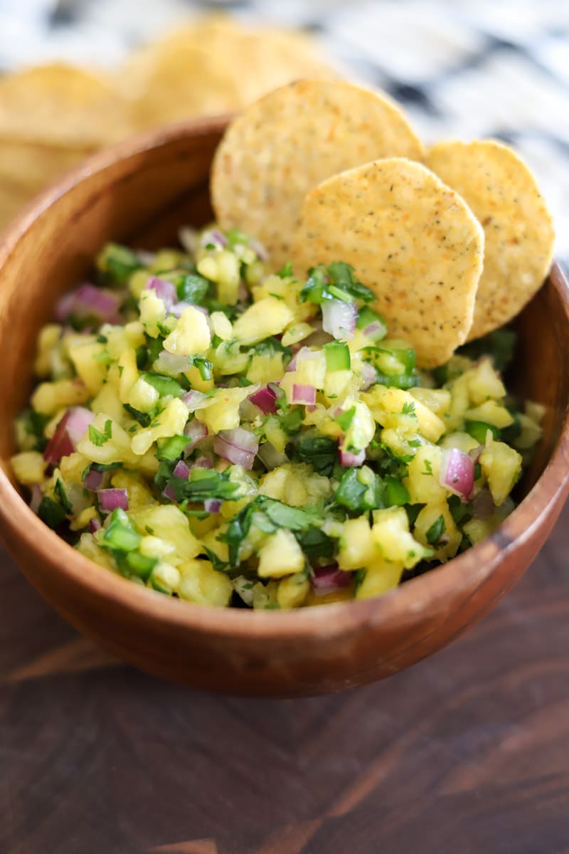 a bowl of pineapple salsa inserted with tortilla chips