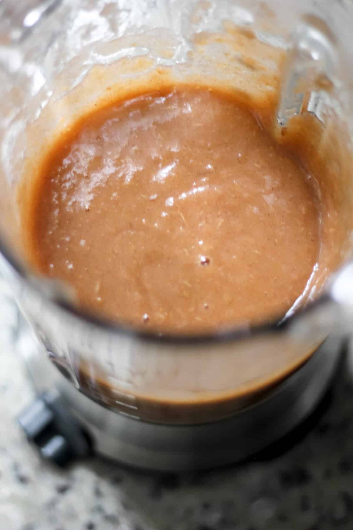 Blended apple butter in a blender jar with a creamy, smooth texture.