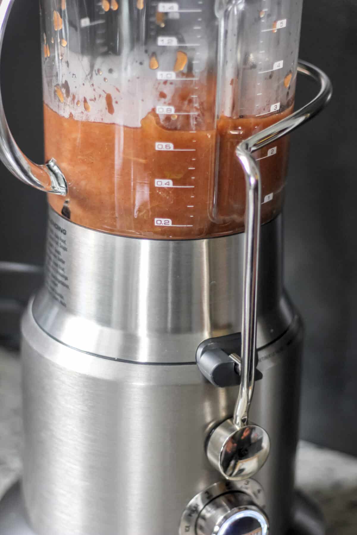 Side view of a blender filled with cooked apple mixture ready to be blended smooth.