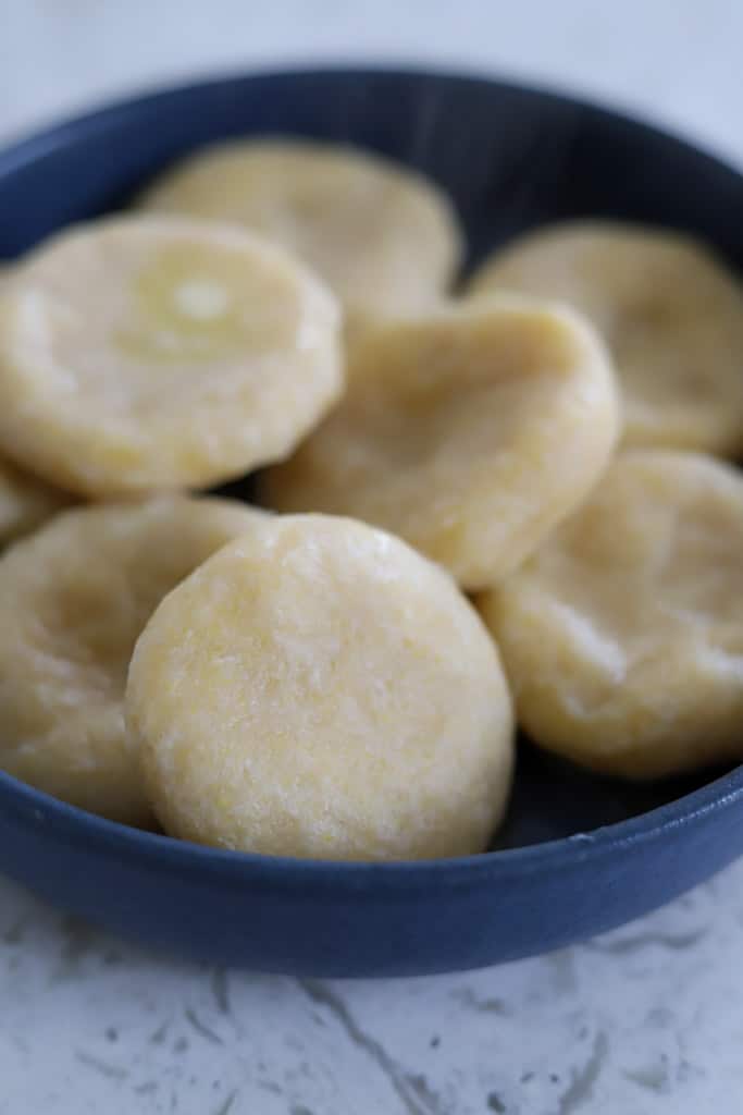 Cooked dumplings drained and placed in a blue bowl.