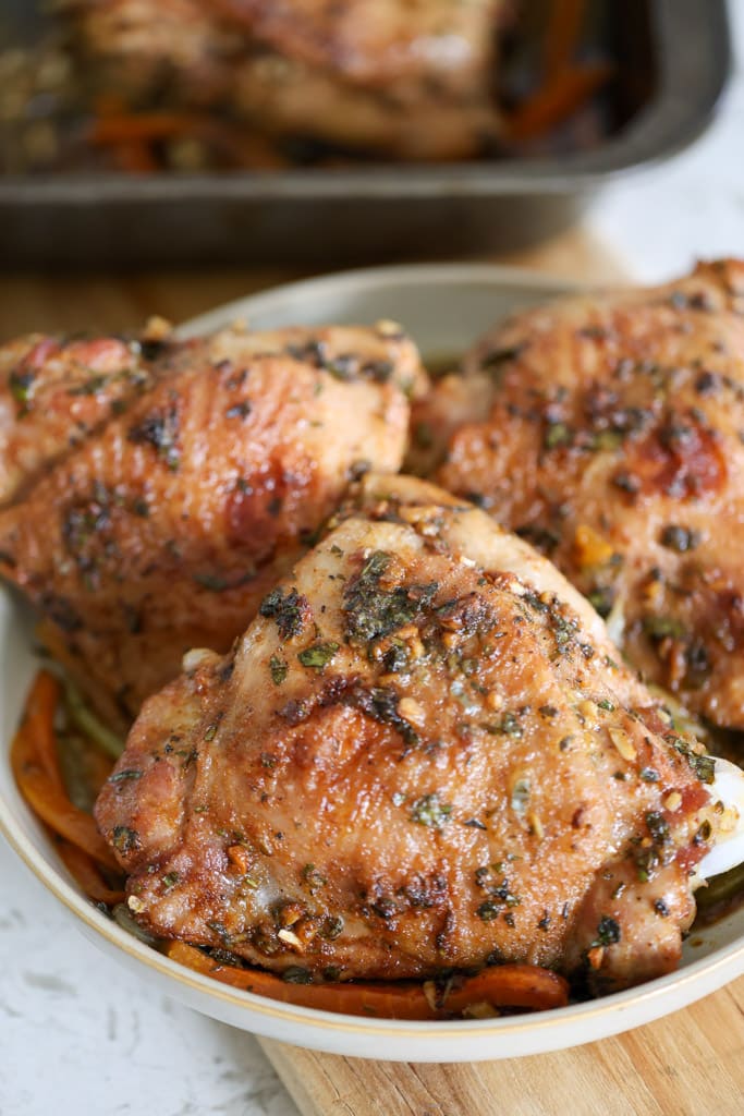 Plate of roasted turkey thighs garnished with herbs.