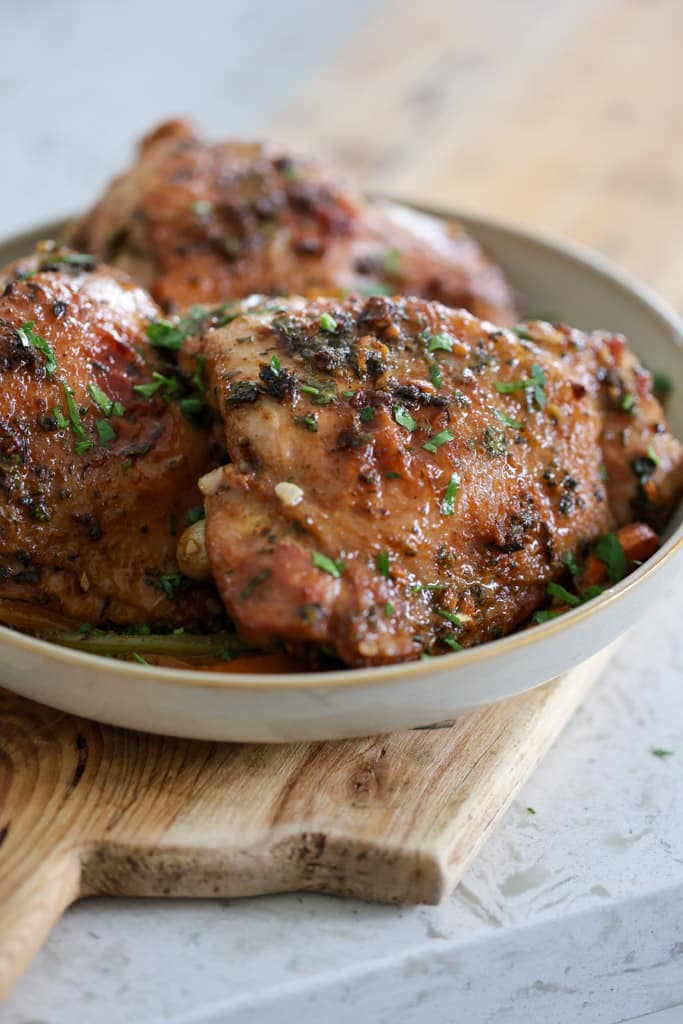 Serving plate filled with golden roasted turkey thighs.