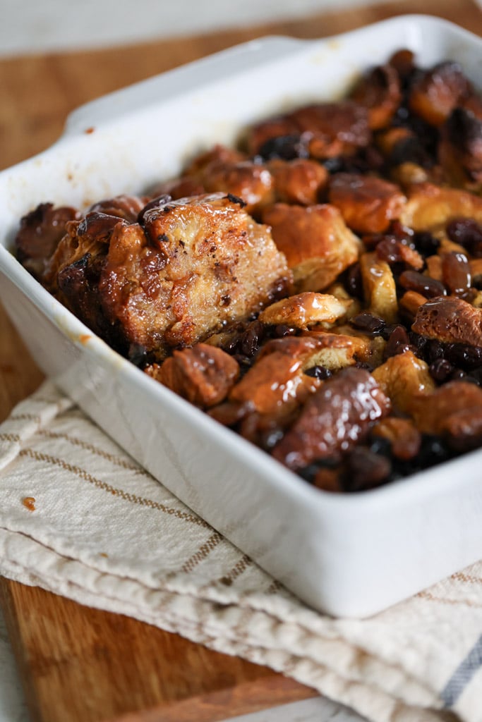 Corner slice of baked bread pudding scooped out of the pan.