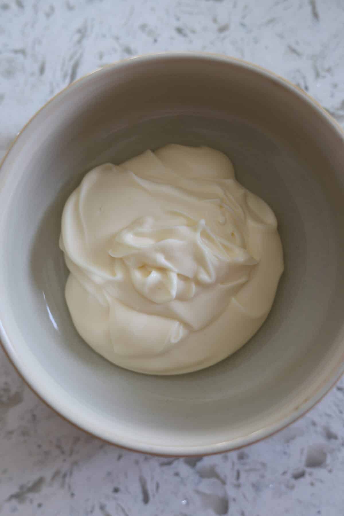 Plain bowl of mayonnaise before adding ingredients.