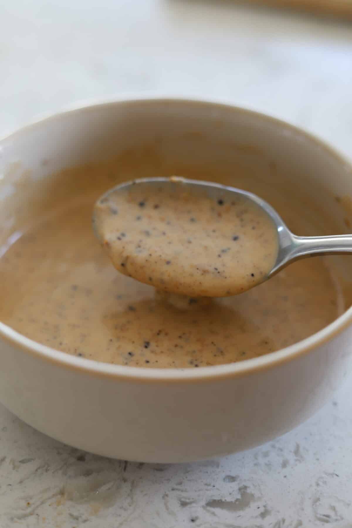 Spoon resting in a bowl of honey jerk mayo.