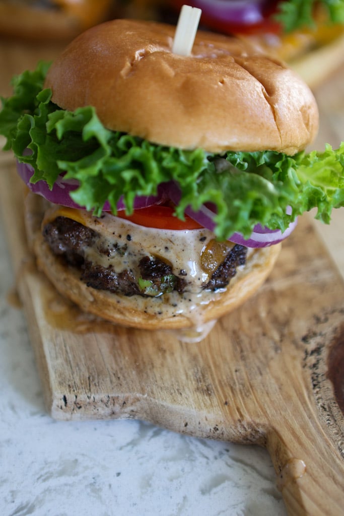 stacked jerk burgers on wooden board.