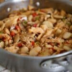 Finished saltfish and butter beans dish in a skillet, showing tender fish and beans coated in sauce.