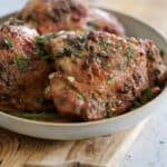 Serving plate filled with golden roasted turkey thighs.