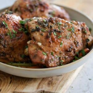 Serving plate filled with golden roasted turkey thighs.
