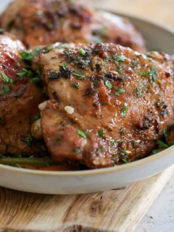 Serving plate filled with golden roasted turkey thighs.
