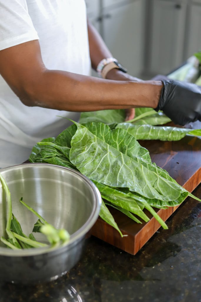 removing stems from collard greens on cutting board