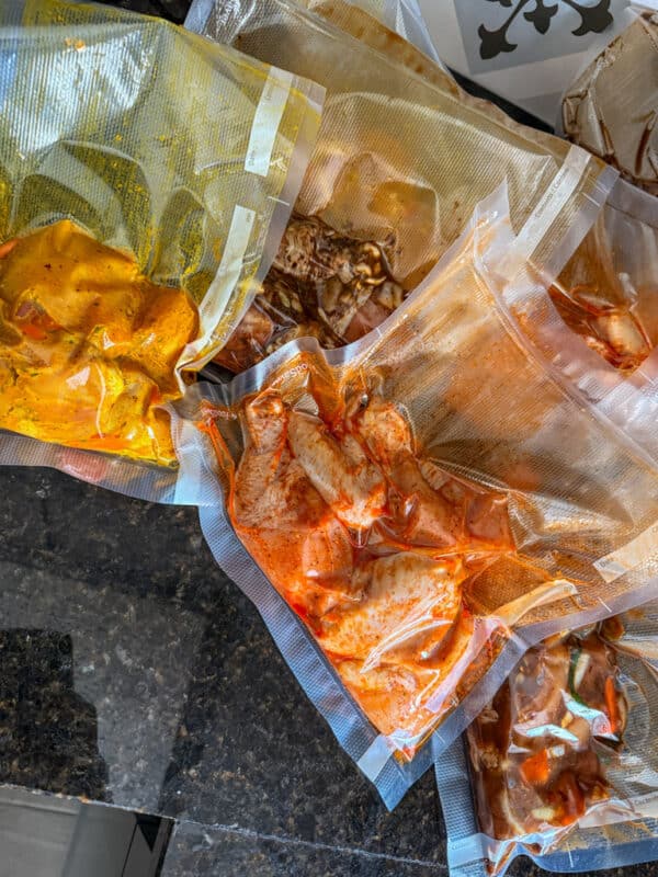 Multiple vacuum-sealed chicken meal prep bags ready for freezer storage.