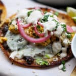 Assembled jerk smash burger taco on a wooden plank.