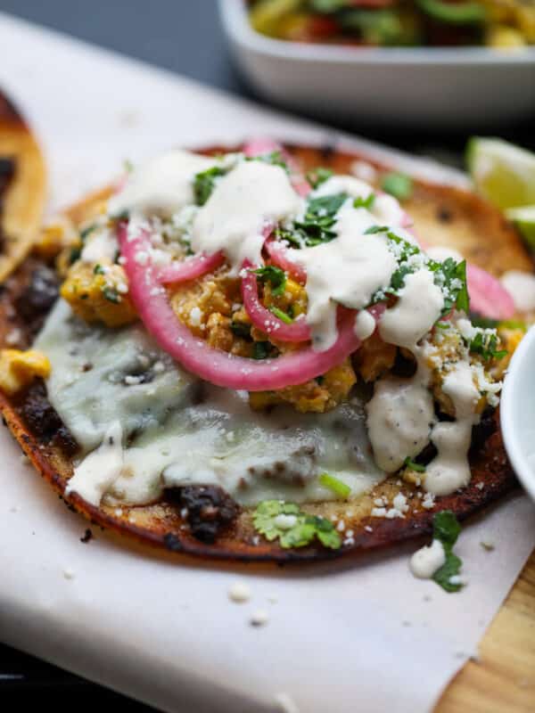 Assembled jerk smash burger taco on a wooden plank.