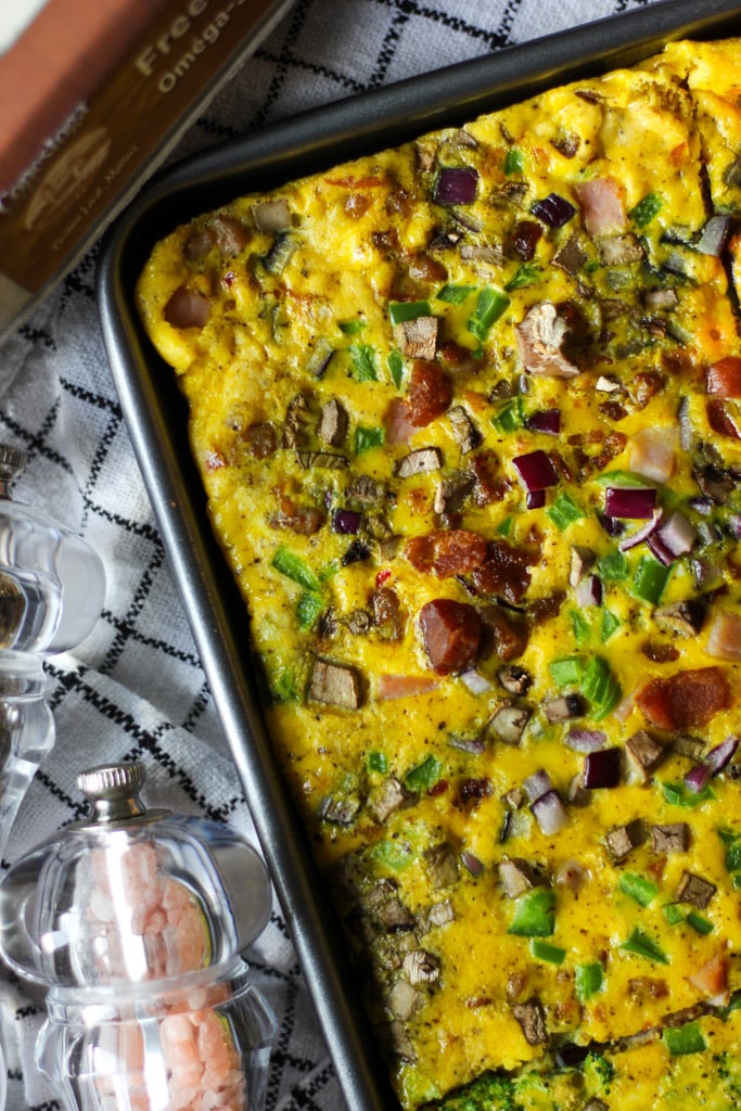 Baked sheet pan omelette topped with bacon, ham, mushrooms, peppers, and onions fresh from the oven.